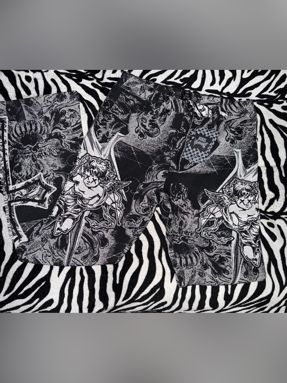Rebel Vengeance black and gray stacked tapestry pants with angel cupid graphics
